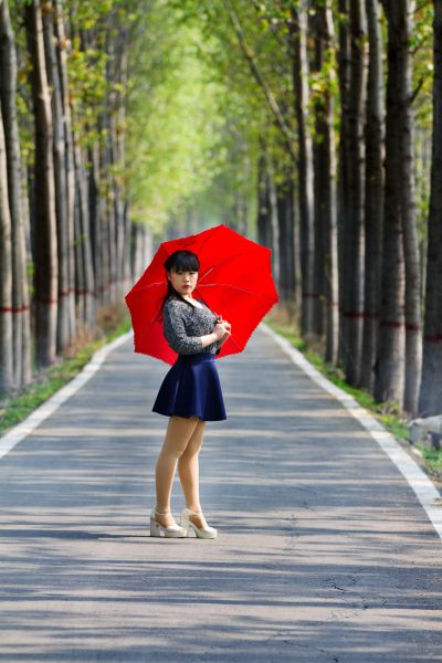 《林间道上红伞倩影》